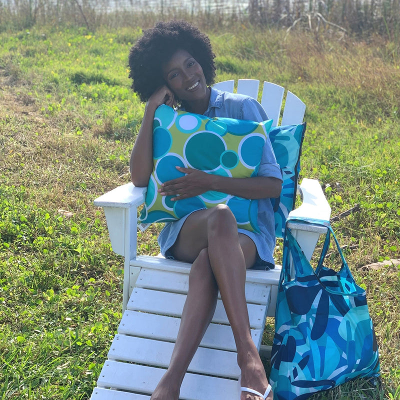 model holding our bubbles pillow cover,  Bubbles pillow cover is in shades of teal and green